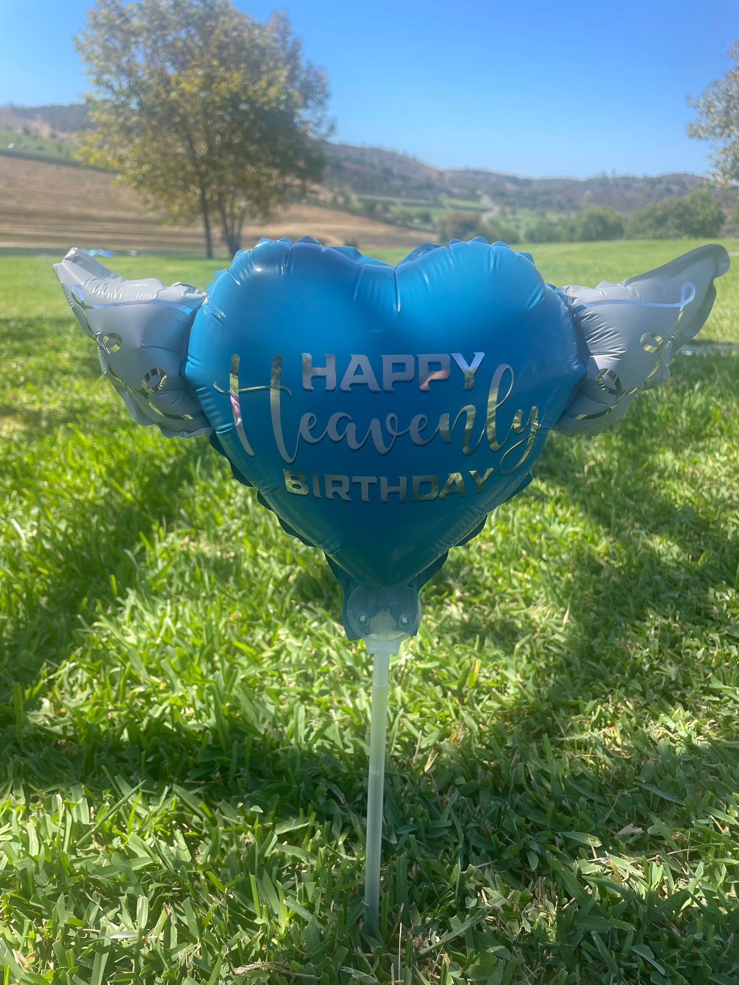 Happy Heavenly Birthday blue balloons on a stick heart shaped with angel wings