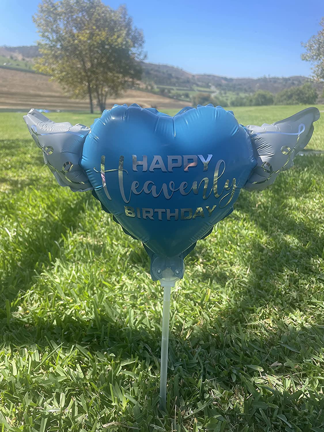 Happy Heavenly Birthday blue balloons on a stick heart shaped with angel wings